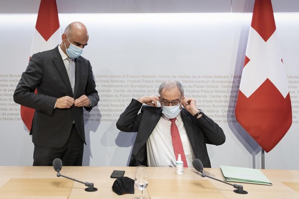 Bundesrat Alain Berset, links, diskutiert Bundespraesident Guy Parmelin am Ende einer Medienkonferenz des Bundesrates zur aktuellen Situation im Zusammenhang mit dem Coronavirus, am Dienstag, 30. Nove ...