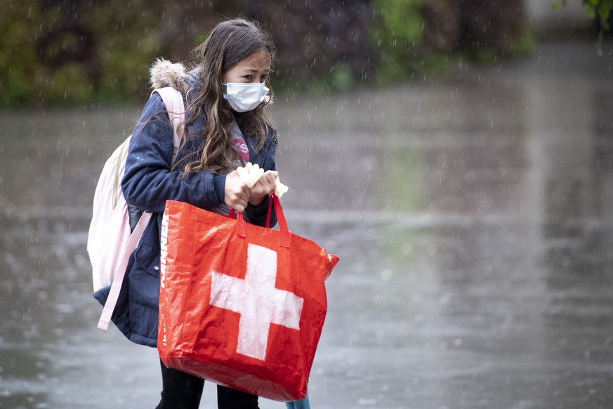 FILE - A pupil wearing a protective mask arrives at a primary school Etablissement Primaire de l&#039;ecole vaudoise, in Morges, Switzerland, 11 May 2020. Classroom teaching at primary and lower secon ...