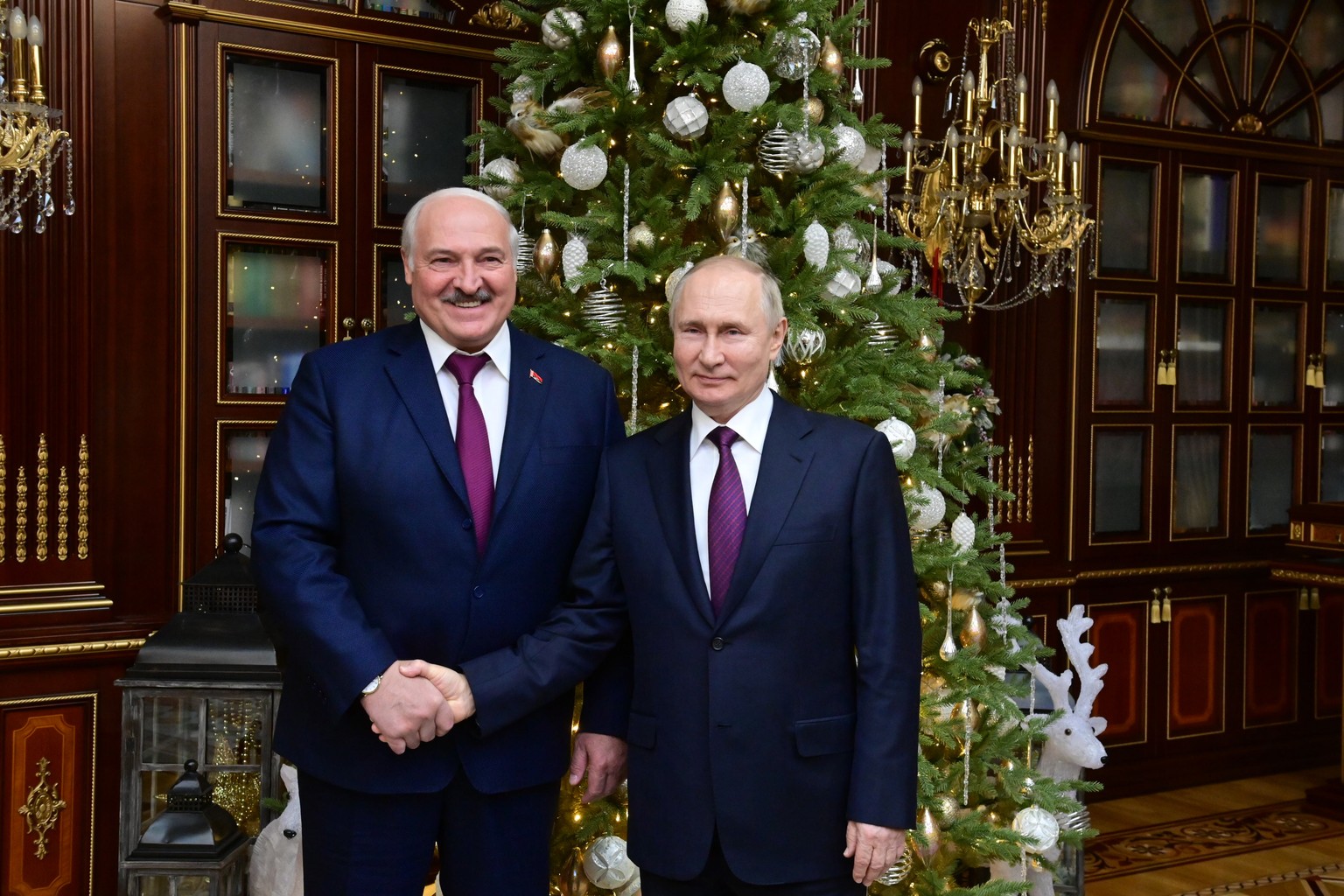 epa10374122 Russian President Vladimir Putin (R) shake hands with his Belarusian counterpart Alexander Lukashenko after a meeting at the Palace of Independence in Minsk, Belarus, 19 December 2022. Pre ...