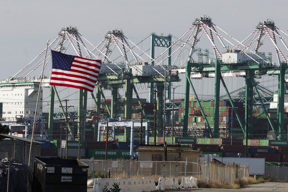 epa12796241 An American flag flutters in the wind in front of STS cranes at the Port of Los Angeles in Los Angeles, California, USA, 04 March 2026. Escalating conflict in the Middle East and the closu ...