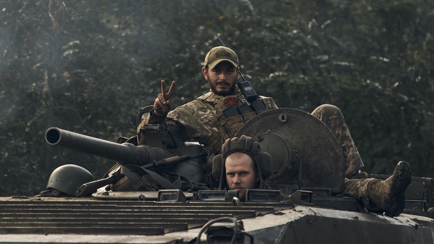 A Ukrainian soldier shows a V-sign atop a vehicle in Izium, Kharkiv region, Ukraine, Tuesday, Sept. 13, 2022. Ukrainian troops piled pressure on retreating Russian forces Tuesday, pressing deeper into ...