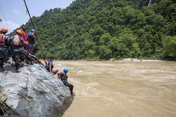 epaselect epa11475472 Members of a rescue team conduct a search and rescue operation after two passenger buses were swept away by a landslide, at Trishuli River in Simaltal, Chitwan district, Nepal, 1 ...