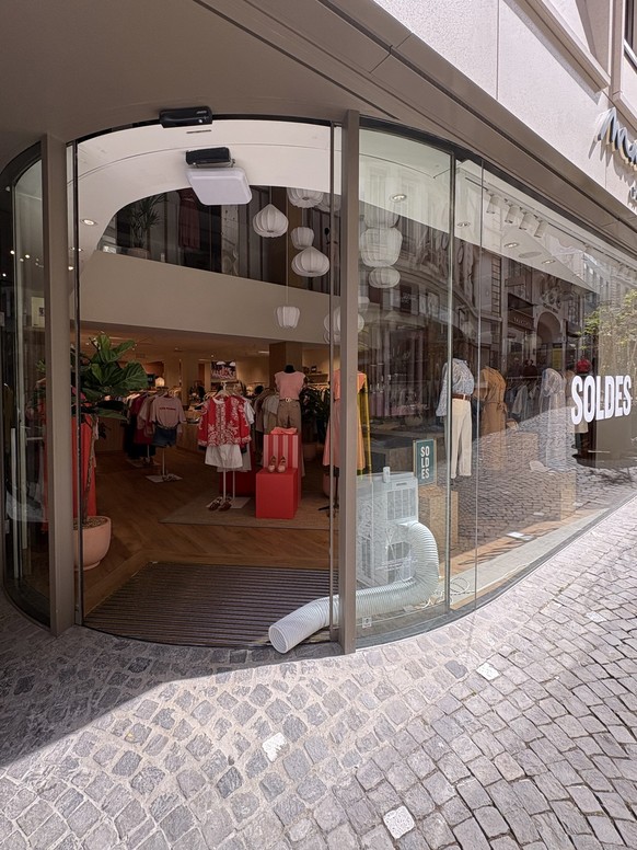 Portes de magasins ouvertes en pleine chaleur pour laisser sortir les tuyaux des climatiseurs