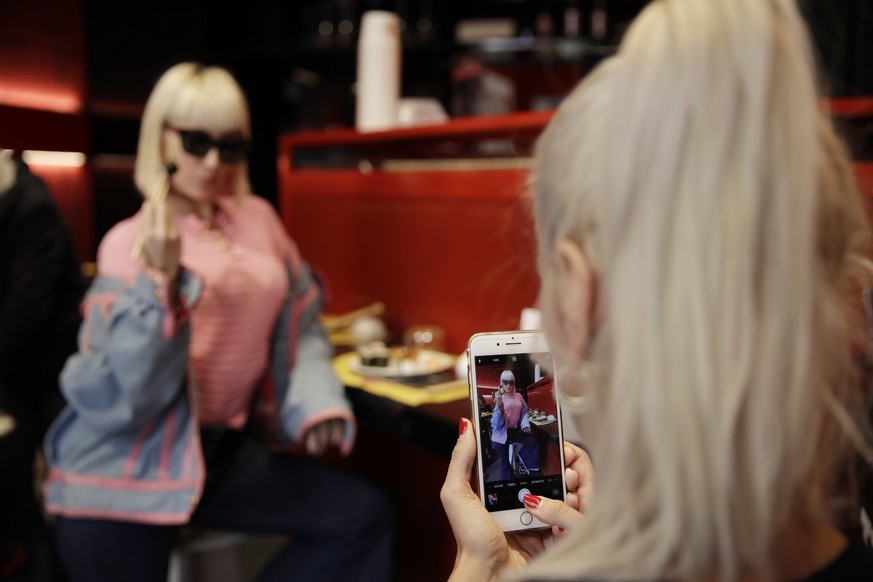 Customer Fashion blogger Clizia Incorvaia, right, takes pictures of her friend singer Vittoria Hyde as they have lunch at the &#039;This is not a Sushi bar&#039; restaurant, in Milan, Italy, Tuesday,  ...