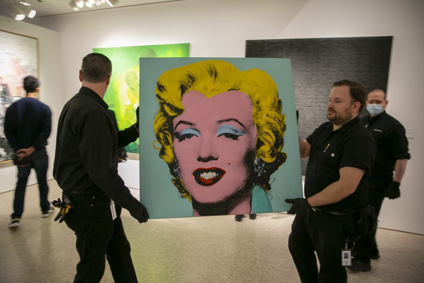 FILE - The 1964 silk-screen image, &quot;Shot Sage Blue Marilyn,&quot; by Andy Warhol is carried in Christie&#039;s showroom in New York, Sunday, May 8, 2022. The image sold for $195 million, Monday,  ...