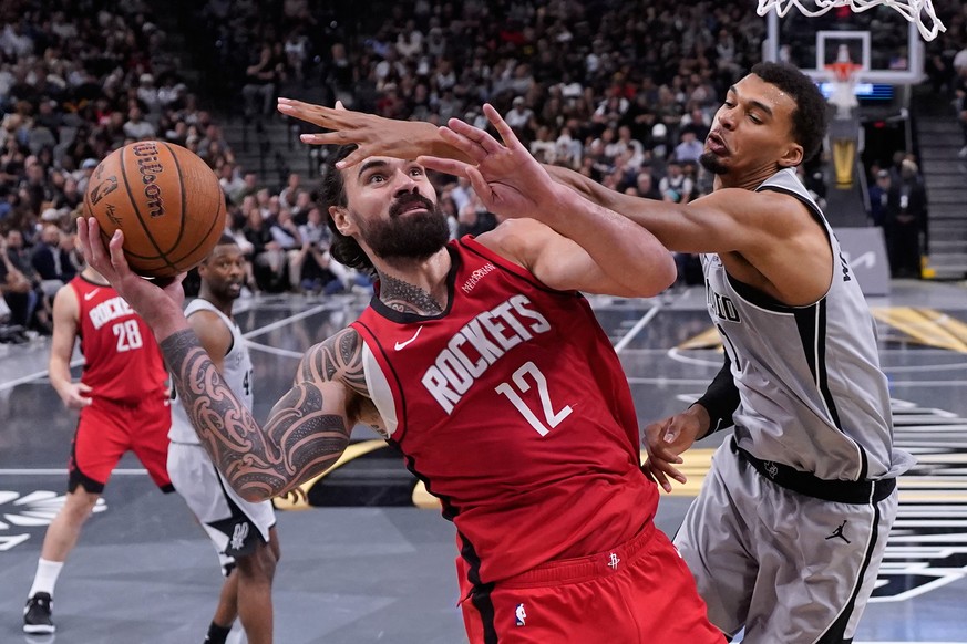 Houston Rockets center Steven Adams (12) is fouled as he tires to shoot past San Antonio Spurs forward Victor Wembanyama (1) during the second half of an NBA Cup basketball game in San Antonio, Friday ...