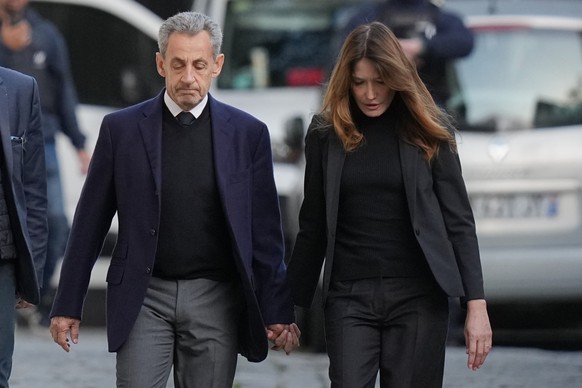 Former French President Nicolas Sarkozy and his wife Carla Bruni-Sarkozy leave their home Tuesday, Oct. 21, 2025 in Paris as Nicolas Sarkozy heads to prison to serve time for a criminal conspiracy to  ...