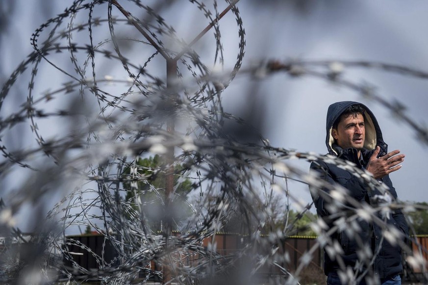 A refugee speaks to journalists behind a barbed wire fence on the Serbian side of Hungary&#039;s southern border with Serbia, near Tompa, Hungary, Thursday, April 6, 2017. (Sandor Ujvari/MTI via AP)