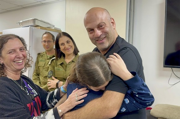 In this photo provided by the Israeli Army, Hila Rotem Shoshani, a released hostage, reunites with her uncle Sunday, Nov. 26, 2023, in Israel. The tense cease-fire between Israel and Hamas appeared to ...