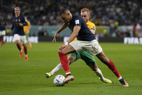 France&#039;s Kylian Mbappe, front. And Australia&#039;s Nathaniel Atkinson fight for the ball during the World Cup group D soccer match between France and Australia, at the Al Janoub Stadium in Al Wa ...