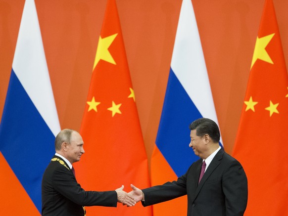 FILE - Chinese President Xi Jinping, right, and Russian President Vladimir Putin shake hands during an awarding ceremony at the Great Hall of the People in Beijing, China, on June 8, 2018. Xi is keepi ...