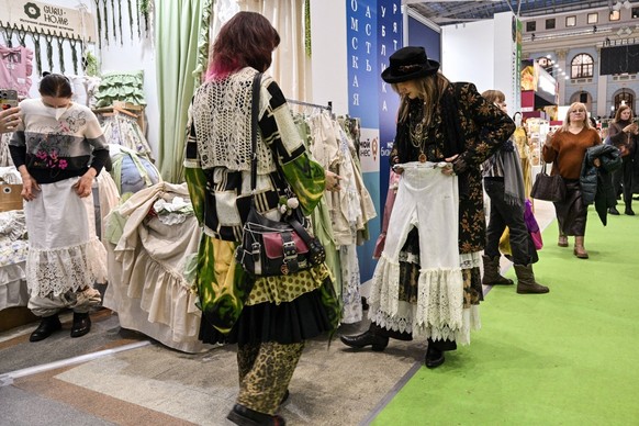 Visitors are seen at the fair of folk and arts craft of Russia, in central Moscow on March 4, 2026. (Photo by Hector RETAMAL / AFP)