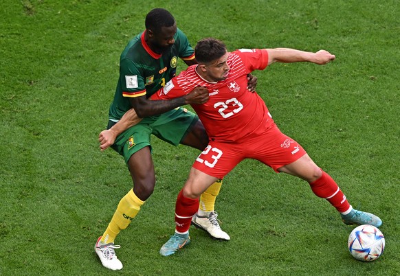 epa10324551 Xherdan Shaqiri (R) of Switzerland in action against Nicolas Nkoulou of Cameroon during the FIFA World Cup 2022 group G soccer match between Switzerland and Cameroon at Al Janoub Stadium i ...