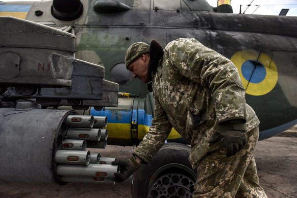 epa10564641 A Ukrainian serviceman loads rockets on an MI-8 helicopter at an undisclosed location in eastern Ukraine, 08 April 2023. Russian troops entered Ukrainian territory on 24 February 2022, sta ...