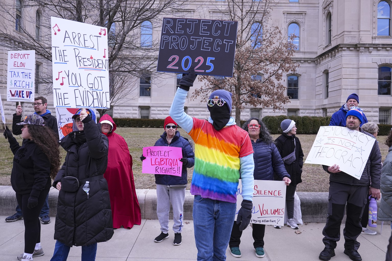 Max Roberts, of Indianapolis, carries a &quot;Reject Project 2025&quot; sign during a protest rally against Project 2025 in Indianapolis, Wednesday, Feb. 5, 2025. (AP Photo/Michael Conroy)