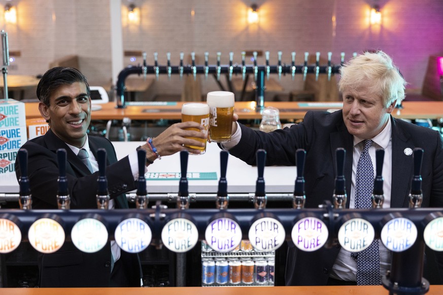 Britain's Prime Minister Boris Johnson, right, with Chancellor of the Exchequer Rishi Sunak during a visit to Fourpure Brewery in London, Wednesday, Oct. 27, 2021, after Sunak delivered his Budge ...