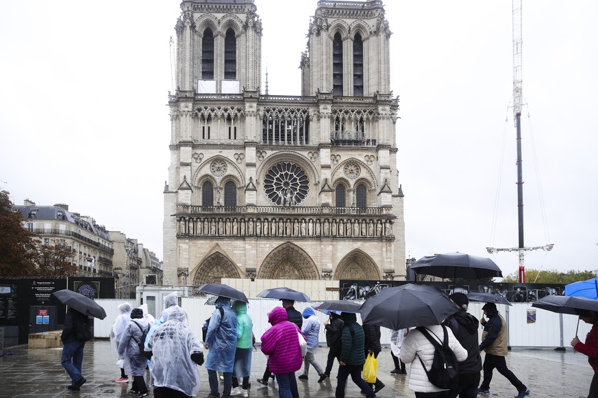 epa11650947 Tourists wearing raincoats and umbrellas near the Notre Dame Cathedral in Paris, France, 09 October 2024. Storm Kirk has caused major disruptions in France&#039;s southwest, resulting in h ...