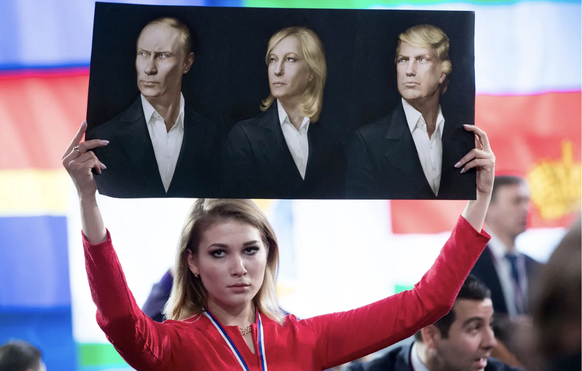 Une journaliste critique de Poutine brandit une banderole simulant Poutine, Le Pen et Donald Trump