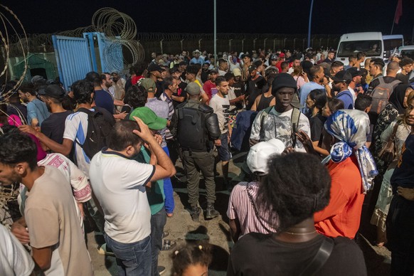 epa13142964 People gather at the Bab Sebta border crossing between Morocco and the Spanish enclave of Ceuta, near Fnideq, Morocco, 30 July 2026. Spain and Morocco agreed to the urgent return of migran ...