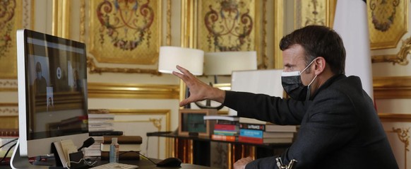 epa09118687 French President Emmanuel Macron speaks to a school manager, teachers and children from the Itard school located in Oraison, southern France, at the Elysee Palace, Paris, France, 06 April  ...