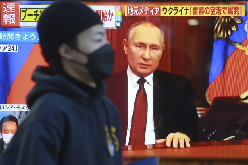 A man walks past a TV screen with image of Russia&#039;s President Vladimir Putin in Tokyo, Thursday, Feb. 24, 2022. As Russian troops attacked Ukraine, world leaders reacted Thursday with outrage, on ...