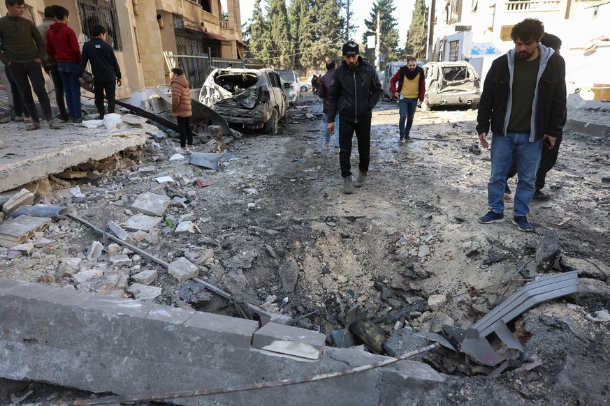 epaselect epa11751369 People inspect the damage after an airstrike in Idlib, northern Syria, 01 December 2024. According to the White Helmets, the Syrian civil group in northwestern Syria, at least ei ...
