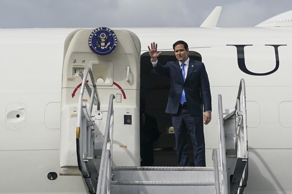 U.S. Secretary of State Marco Rubio gestures as he boards an aircraft en route Suriname at Cheddi Jagan International Airport in Georgetown, Guyana, Thursday, March 27, 2025. (Nathan Howard/Pool photo ...