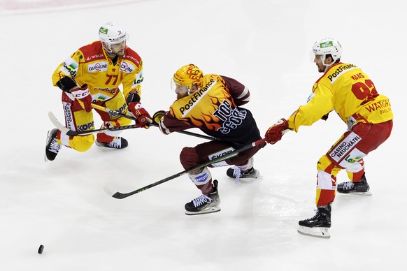 Geneve-Servette&#039;s forward Tanner Richard, centre, vies for the puck with Biel&#039;s defender Robin Grossmann, left, and Biel&#039;s forward Haas Gaetan Haas, right, during the fifth leg of the N ...