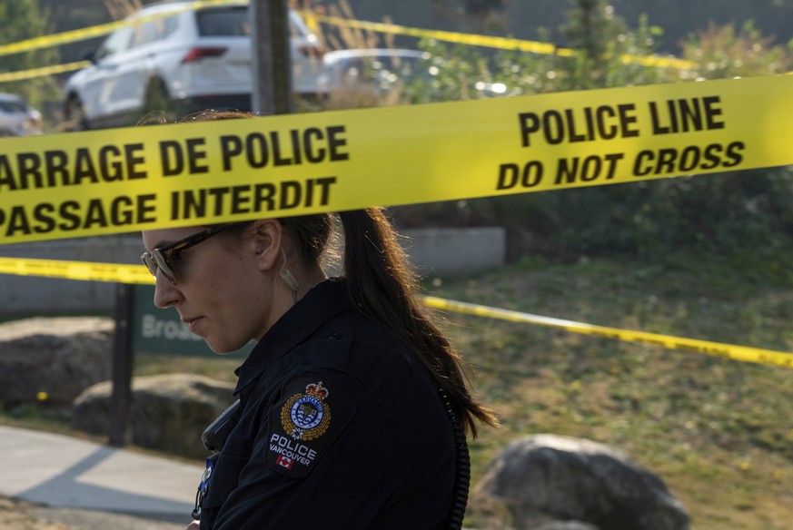 A Vancouver Police Department officer is seen near a homeless encampment where a female member of the Royal Canadian Mounted Police was stabbed to death in Burnaby, British Columbia, Tuesday, Oct. 18, ...