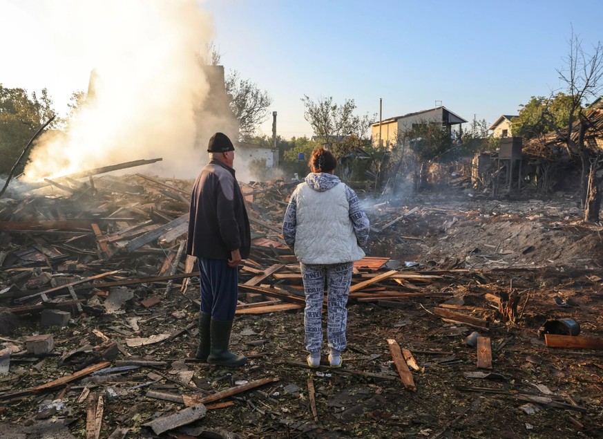 Après les violentes attaques du 30 septembre, ces deux habitants d'une banlieue de Kiev se tiennent devant les décombres de leur maison.
