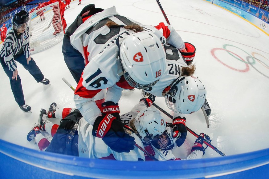 epa09748573 Alina Muller (bottom) of Switzerland celebrates with teammates after scoring during the Women&#039;s Ice Hockey Play-offs Quarterfinals match between the Russian Olympic Committee and Swit ...
