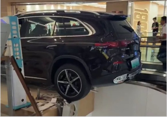 Un SUV Mercedes neuf a reculé dans un showroom à Handan, en Chine, brisant une balustrade en verre et restant suspendu au-dessus d’un escalator.