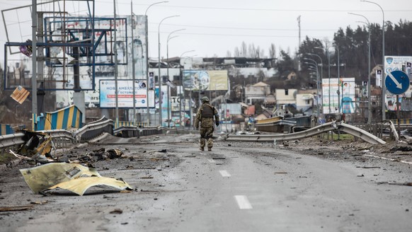 butscha, butcha, Ukraine-Konflikt, Eindrücke nach Kämpfen in Bucha April 2, 2022, Bucha, Ukraine: (EDITORS NOTE: Image depicts death) An Ukrainian soldiers walks along dead corpses on a destroyed road ...