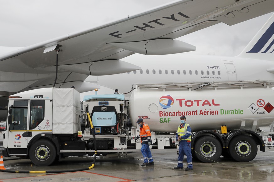 Workers refuel an Airbus A350 with sustainable aviation fuel at Roissy airport, north of Paris, Tuesday, May 18, 2021. Air France-KLM is sending into the air what it calls its first long-haul flight w ...
