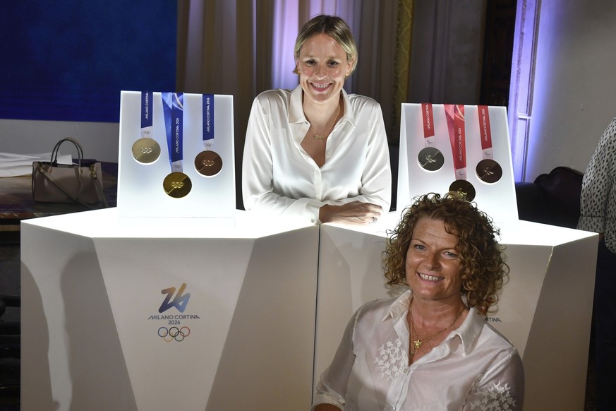 Former Italian swimmer Federica Pellegrini, top, and Paralympic athlete Francesca Porcellato pose for photographers next to Milano Cortina 2026 Winter Olympics and Paralympics medals during the unveil ...