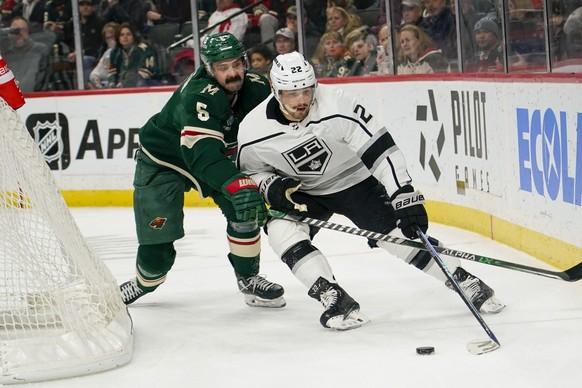 Minnesota Wild defenseman Jacob Middleton (5) tries to knock the puck away from Los Angeles Kings left wing Kevin Fiala (22) during the second period of an NHL hockey game Tuesday, Feb. 21, 2023, in S ...