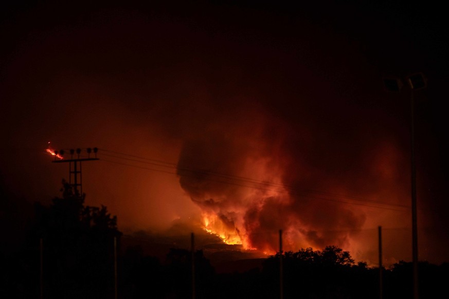 Un incendie de forêt se propage et illumine l'horizon près de la zone urbaine de Buenaventura, à Avila, à l'ouest de Madrid, le 26 juillet 2026.