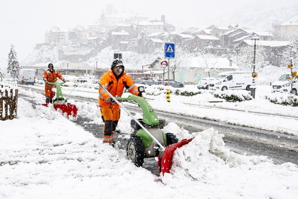 Deux employes de la commune enlevent la neige sur une route avec des machines le jeudi 17 avril 2025 a Saillon en Valais. Les fortes precipitations, qui s&#039;abattent sur le Valais depuis mercredi,  ...