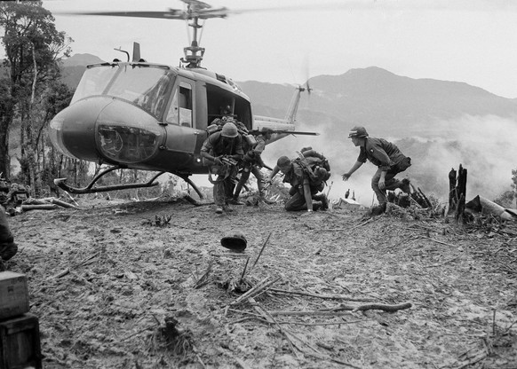 Paratroopers rush to help a wounded comrade after being evacuated off 3000-foot Dong Ap Bia, aka, &amp;quot;Hamburger Hill,&amp;quot; a North Vietnamese-held hill on the western edge of the A Shau Val ...