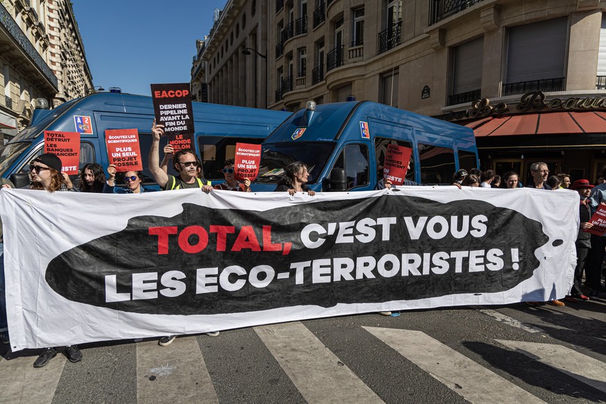epa10654753 French environmental activists hold a banner reading: &#039;Total you?re the Eco-Terrorists? as they attempt to block shareholders from attending the meeting in Paris, France, 26 May 2023. ...