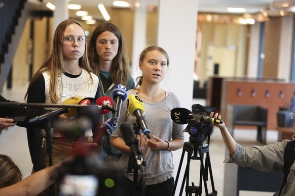 epa10765844 Swedish climate activist Greta Thunberg (R) speaks to the press following a court appearance in Malmo, Sweden, 24 July 2023. Thunberg is charged with disobeying police at a climate action ...