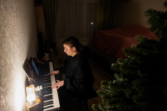 Local resident an piano teacher Evgenia plays the piano with a flashlight in her apartment, during a blackout in Kyiv, in the evening of January 13, 2026, amid the Russian invasion of Ukraine. (Photo  ...