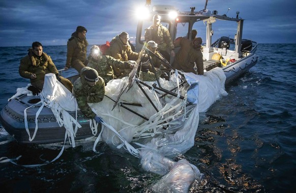 In this photo provided by the U.S. Navy, sailors assigned to Explosive Ordnance Disposal Group 2 recover a high-altitude surveillance balloon off the coast of Myrtle Beach, S.C., Feb. 5, 2023. (U.S. N ...