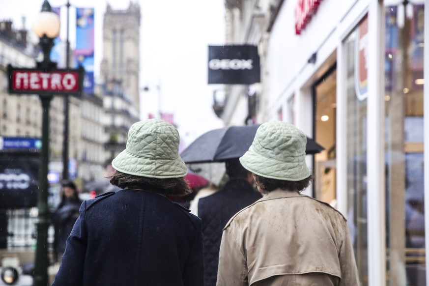 epa11650941 Women with rain hats walk cross a commercial street in the center of Paris, France, 09 October 2024. Storm Kirk has caused major disruptions in France&#039;s southwest, resulting in high w ...
