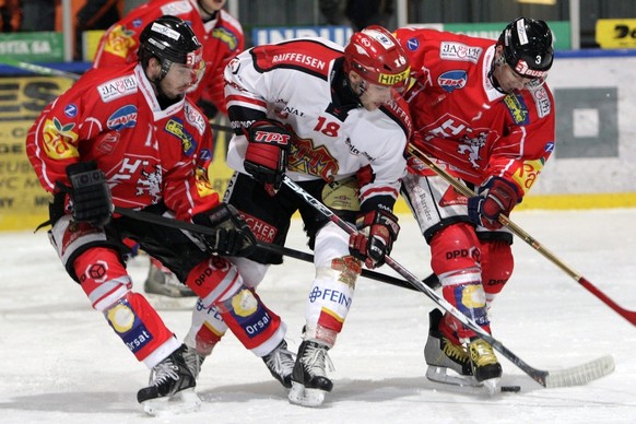 Les joueurs valaisan Karl Moser, gauche, et Vincent Ermacora, droite lutte pour le puck avec le joueur biennois Alain Mieville, centre, lors du match de LNB du championnat suisse de hockey sur glace,  ...