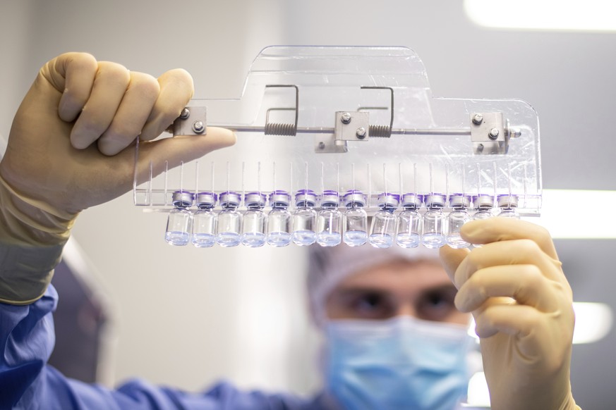 FILE - In this March 2021 photo provided by Pfizer, a technician inspects filled vials of the Pfizer-BioNTech COVID-19 vaccine at the company&#039;s facility in Puurs, Belgium. Pfizer and Moderna have ...