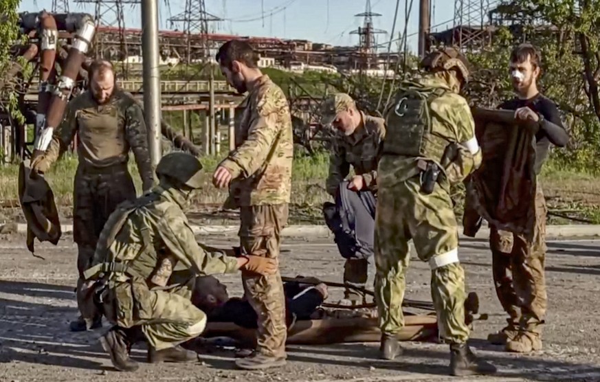 Des soldats russes fouillent des combattants ukrainiens à l'aciérie d'Azovstal à Marioupol.