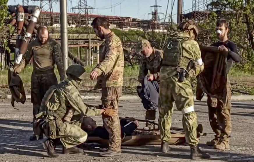 epa09952366 A handout still image taken from a handout video made available by the Russian Defence Ministry&#039;s press service shows Russian soldiers frisking Ukrainian servicemen as they are being  ...