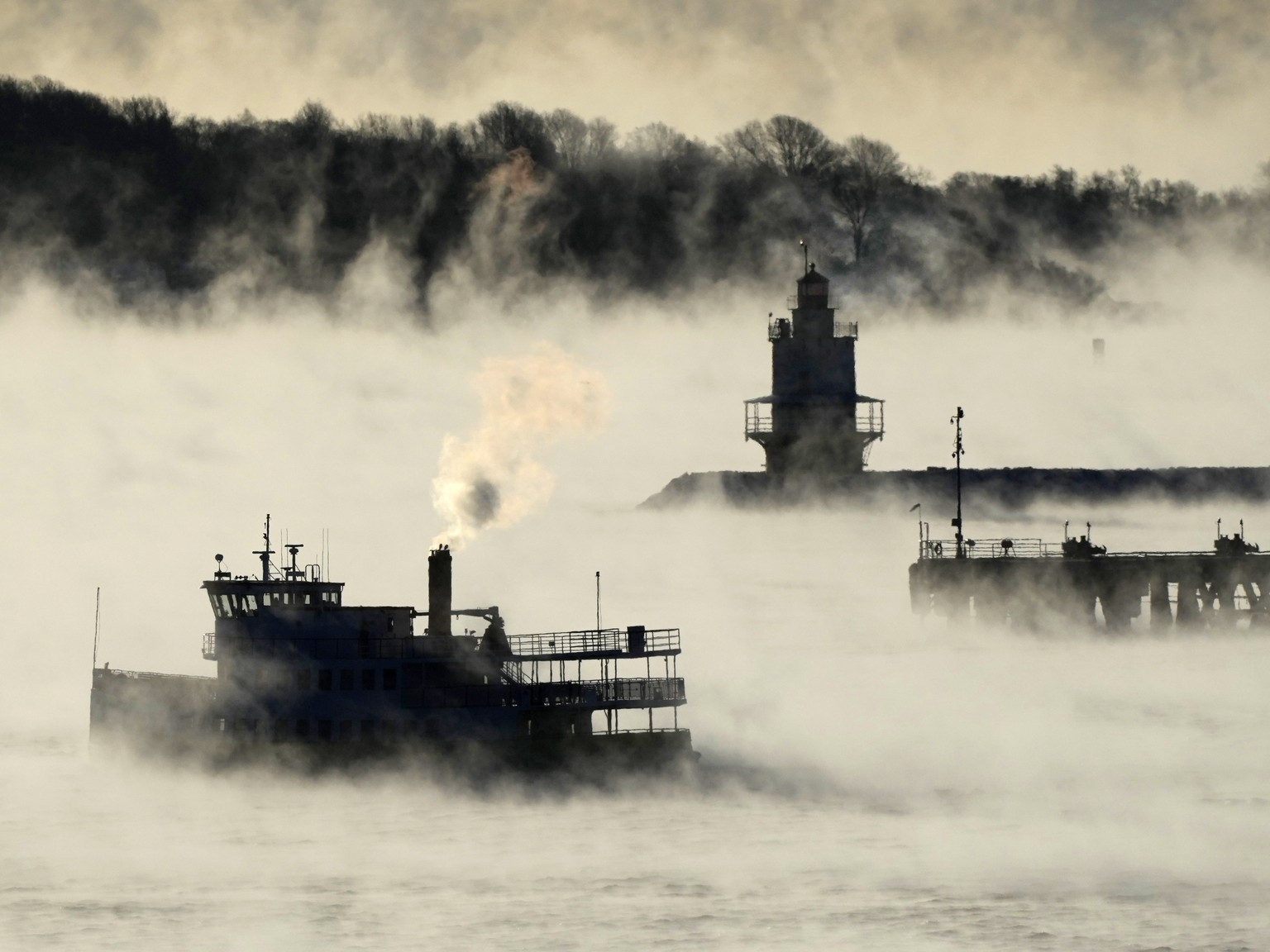Arctic sea smoke rises from the the Atlantic Ocean as a passenger ferry passes Spring Point Ledge Light, Saturday, Feb. 4, 2023, off the coast of South Portland, Maine. The morning temperature was abo ...