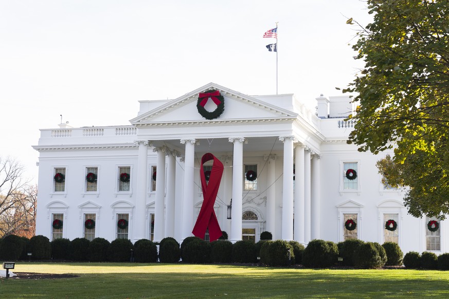 The North Portico of the White House is adorned with a huge red ribbon to commemorate the annual World AIDS Day, Wednesday, Dec. 1, 2021, in Washington. The Biden administration in its new HIV/AIDS st ...